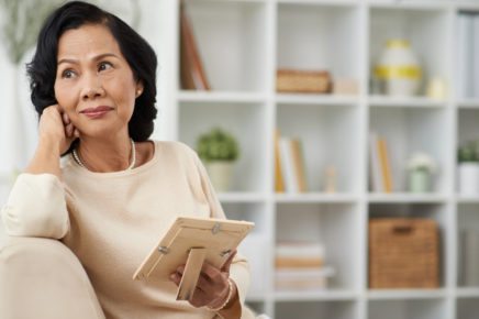 Widow holds picture of husband with thoughtful look