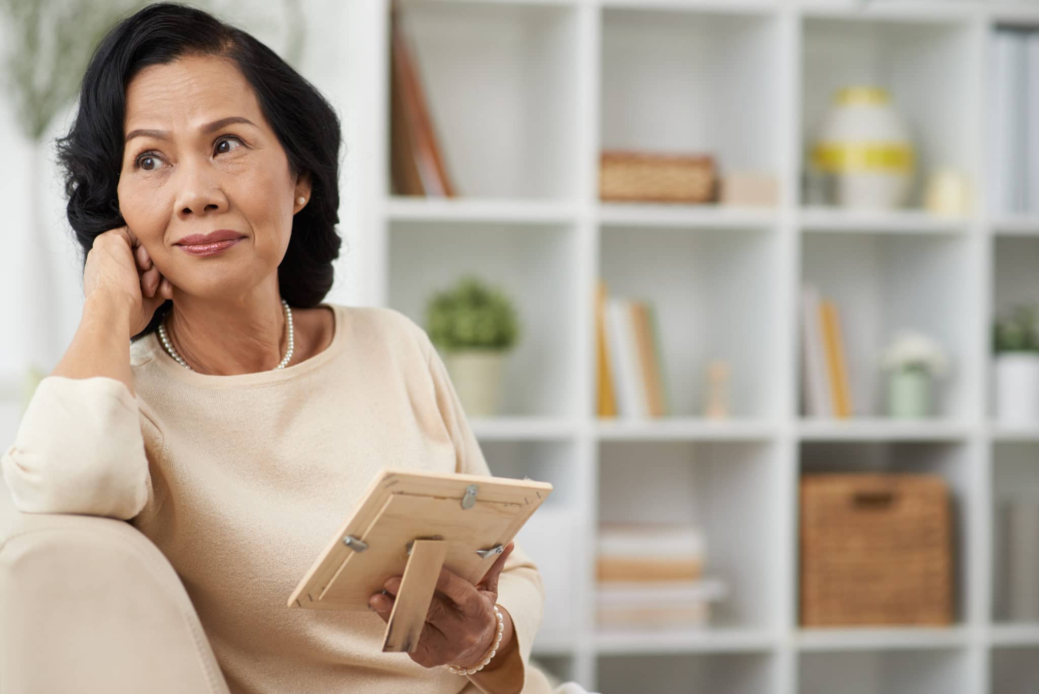 Widow holds picture of husband with thoughtful look
